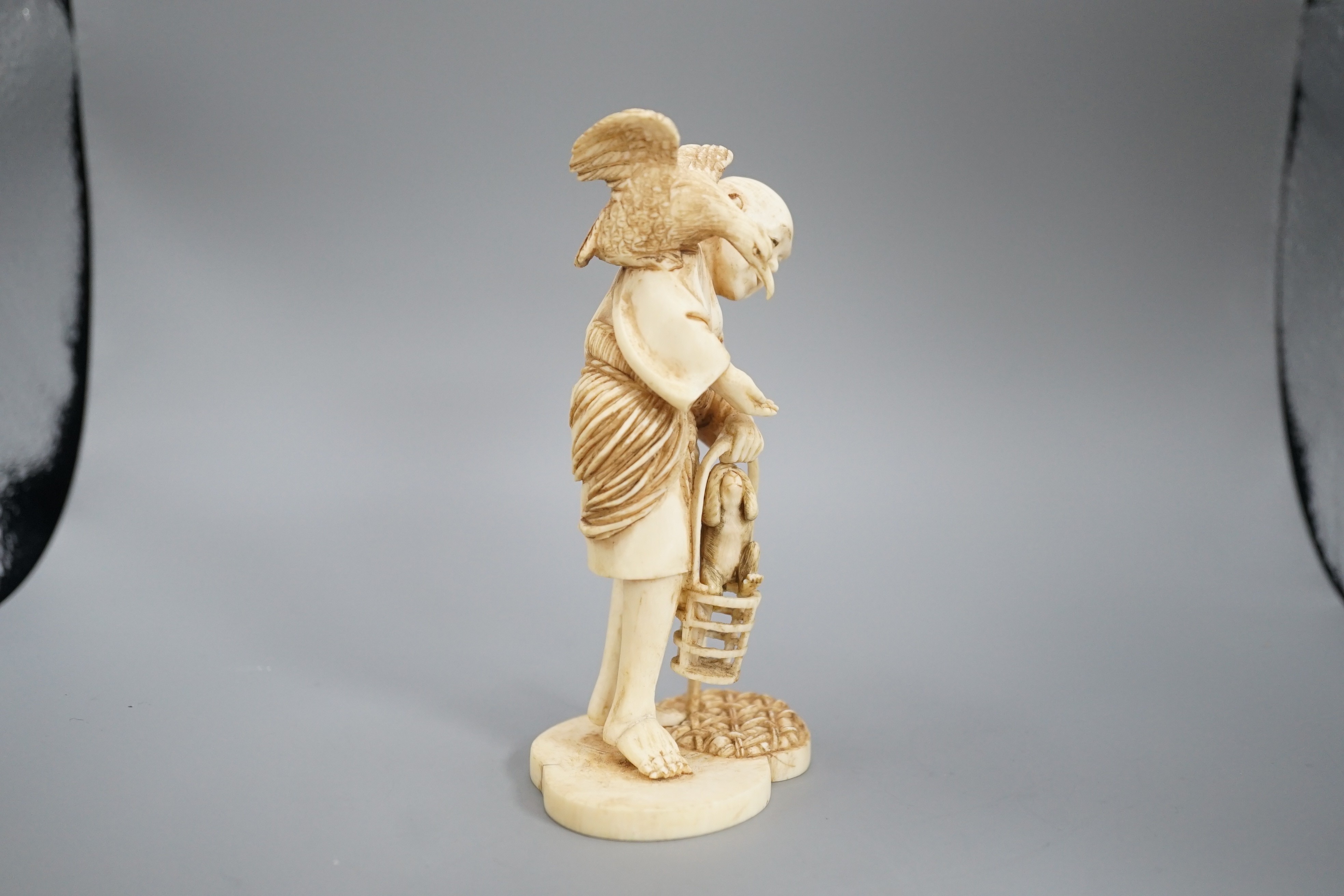 A Japanese ivory okimono of a cormorant fisherman, signed, Meiji period, 11cm and a small carving of a monkey